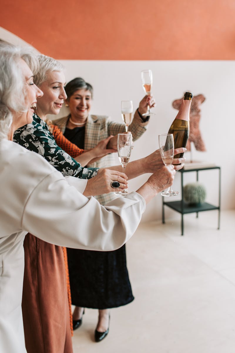 A joyful group of senior women toasting with champagne glasses.